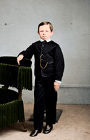 Tad Lincoln, standing, leaning against a chair