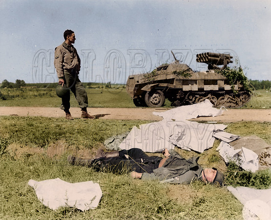 An American soldier gazes out in company with a dead German soldier and a Moaning Minnie