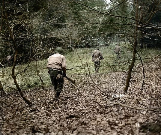 GIs from U.S. First Army hunt German paratroopers dropped during the Bulge, Belgium, Dec. 18, 1944.